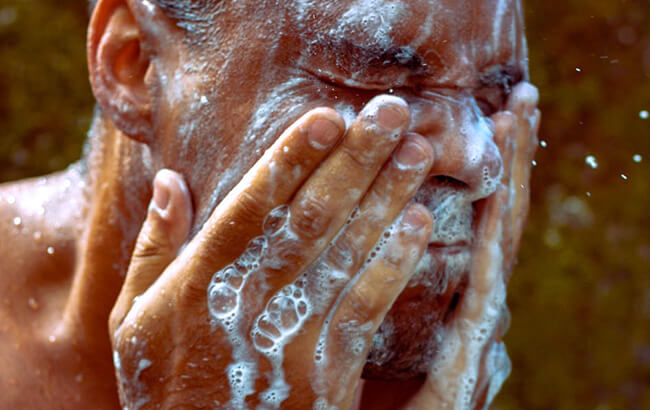man washing face