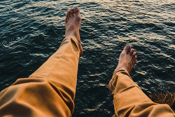 man's feet in the sea